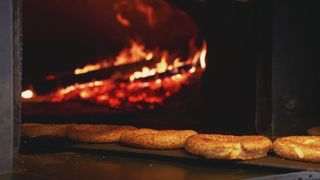 Bread baking beside glowing embers in the bakery mosaic.